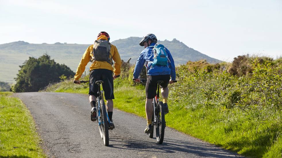 two cyclists side by side on country road